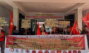 Serbu PT. PAP membentangkan spanduk dan membawa petaka yang berisi tuntutan mereka saat menggelar aksi unjukrasa di Kantor Disnakertrans Sulsel